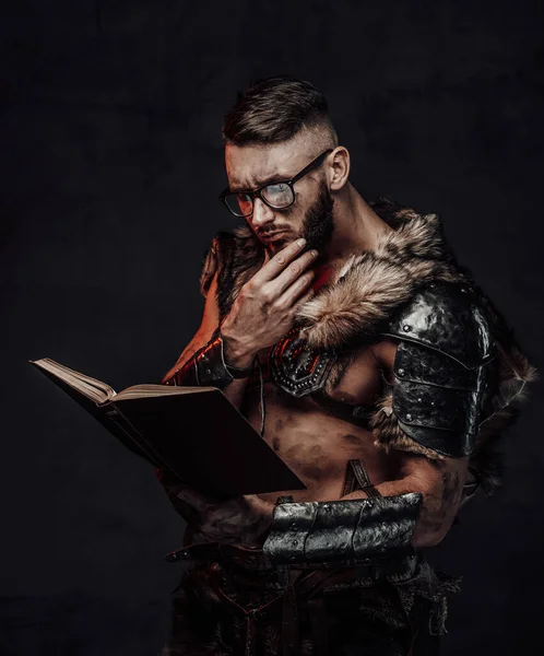 Inteligente vikingo leyendo un libro en un fondo oscuro — Foto de Stock