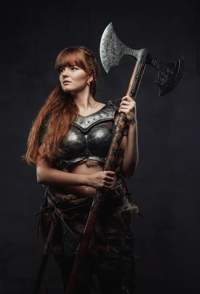 Female nordic fighter holding two handed axe in dark background — Stock Photo, Image