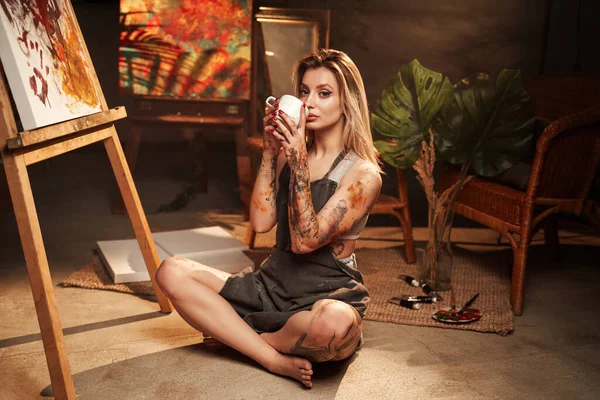 Bere caffè pittore femminile in studio scuro — Foto Stock