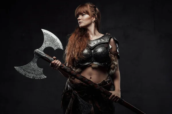 Female nordic fighter holding two handed axe in dark background — Stock Photo, Image