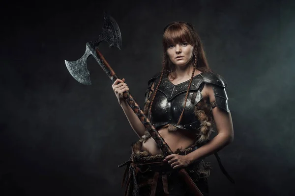 Viking feminino guerreiro armado com enorme machado em fundo nebuloso — Fotografia de Stock