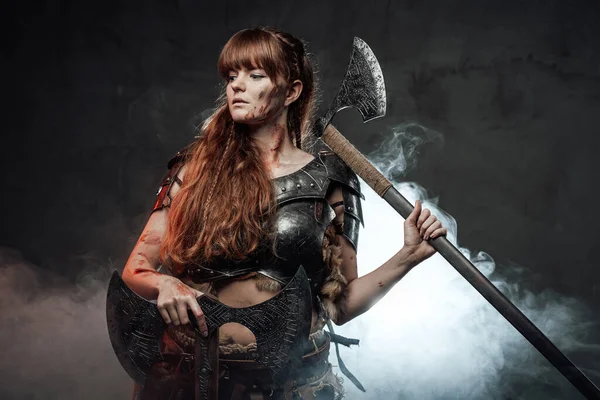 Young nordic amazon with two axes in smokey background — Stock Photo, Image