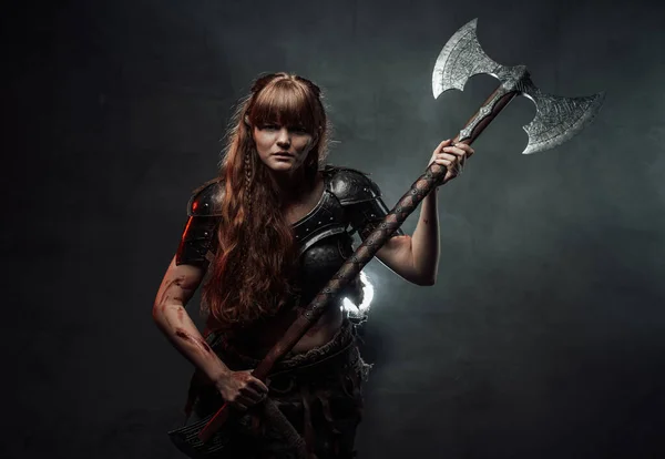 Furious nordic amazon with two handed axe in dark background — Stock Photo, Image