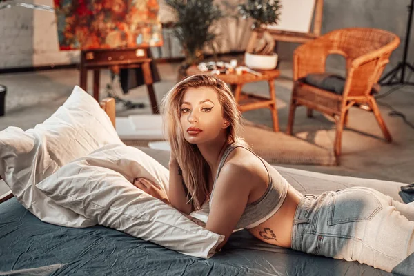 Красива жінка позує на ліжку в кімнаті з бамбуковими меблями — стокове фото