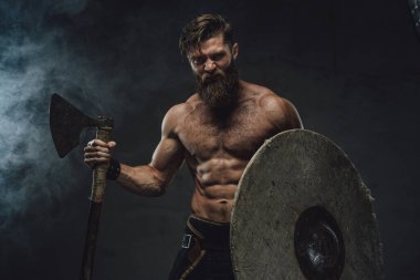 Karanlık arka planda balta ve miğferli Ortaçağ Vikingleri