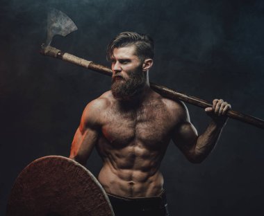 İki eli baltayla arka planda İskandinav savaşçısı