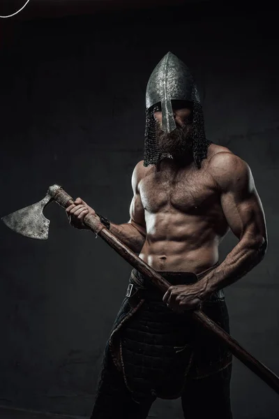 Guerreiro nórdico posando com seu machado em fundo escuro — Fotografia de Stock