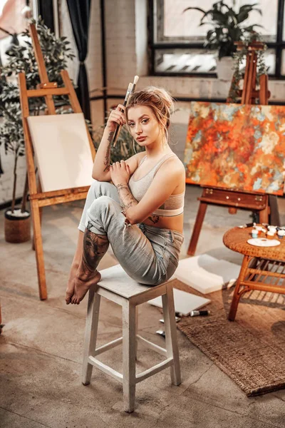 Красива жінка-художник сидить на стільці з пензлями — стокове фото