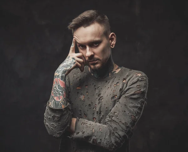 Hipster person poserar i mörk bakgrund med fingret mot huvudet — Stockfoto
