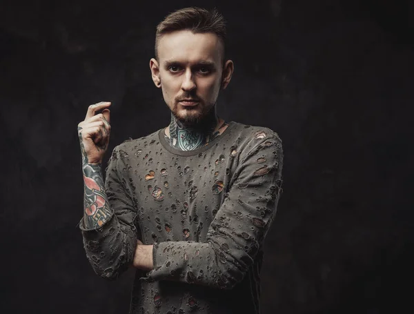 Pensativo hipster posa en fondo oscuro en camisa andrajosa —  Fotos de Stock