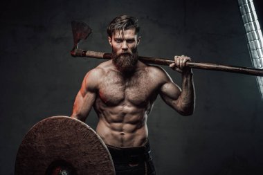 Karanlık arka planda balta ve miğferli Ortaçağ Vikingleri