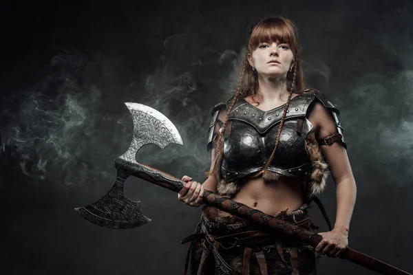 Viking feminino guerreiro armado com enorme machado em fundo nebuloso — Fotografia de Stock