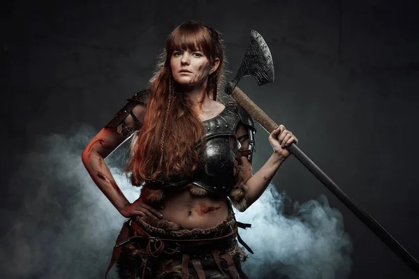 Mulher nórdica combativa com machado em fundo fumado — Fotografia de Stock