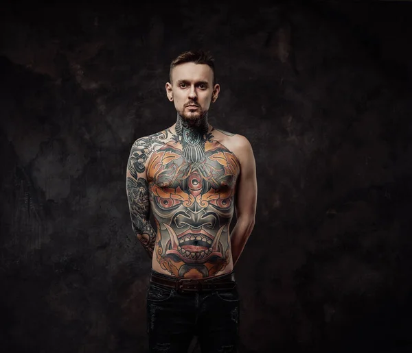 Naked tattooed hipster poses in dark background looking at camera — Stock Photo, Image
