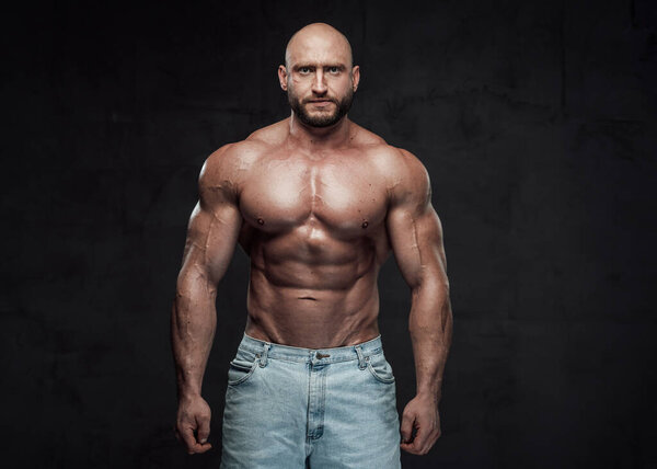 Handsome caucasian bodybuilder posing in dark background