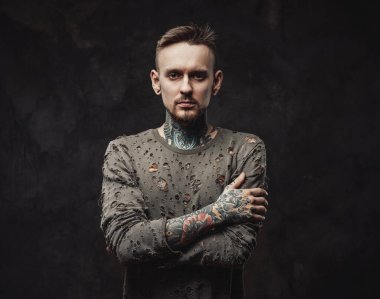 Paçavra gömlekli, esmer arka planda dalgın bir hipster.