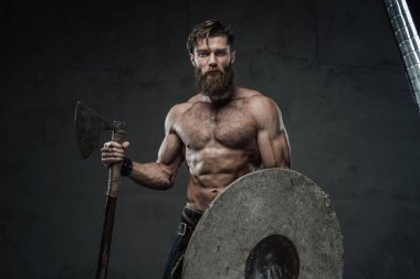 Karanlık arka planda balta ve miğferli Ortaçağ Vikingleri