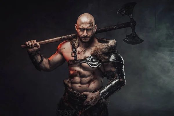 Holding axe on his shoulder savage nordic warrior in smokey background — Stock Photo, Image