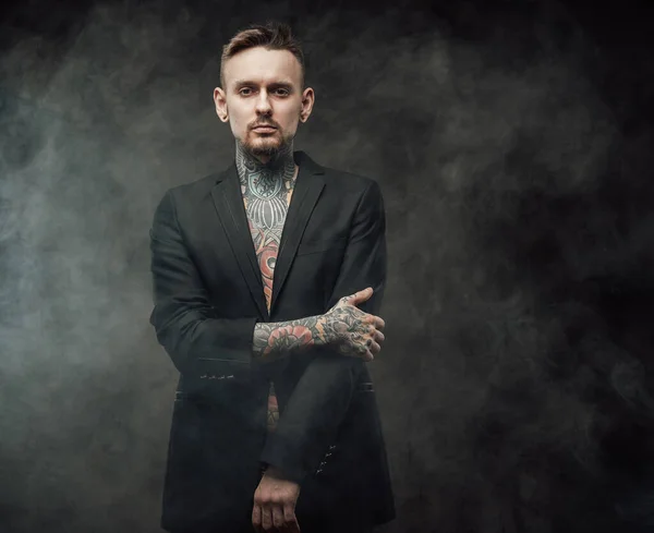 Hombre serio tatuado en chaqueta con corte de pelo elegante en fondo oscuro —  Fotos de Stock