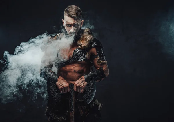 Őrült skandináv harcos hatalmas baltával sötét füstös háttérben — Stock Fotó