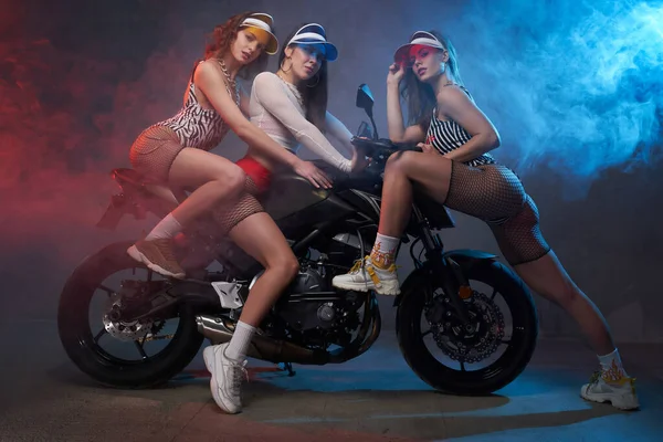 Styled and colorful girls and studio with motorbike — Stock Photo, Image