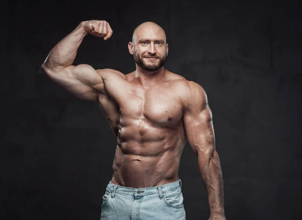 Fröhlicher kaukasischer Bodybuilder mit nacktem Oberkörper im dunklen Hintergrund — Stockfoto