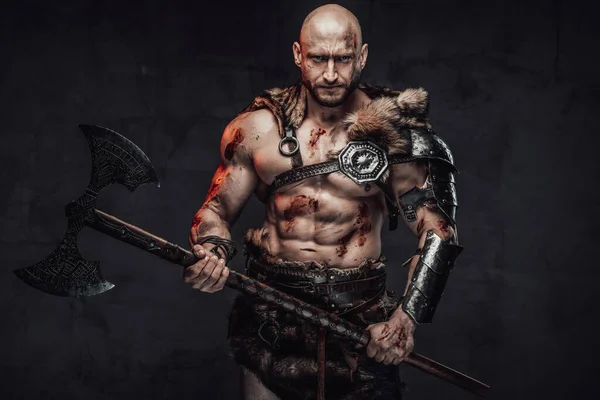 Bloody and furious viking armed with axe posing in dark background — Stock Photo, Image