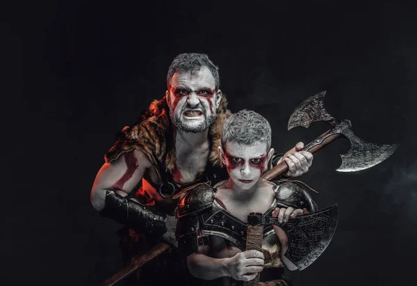 Posando juntos padre e hijo belicosos en un fondo oscuro —  Fotos de Stock