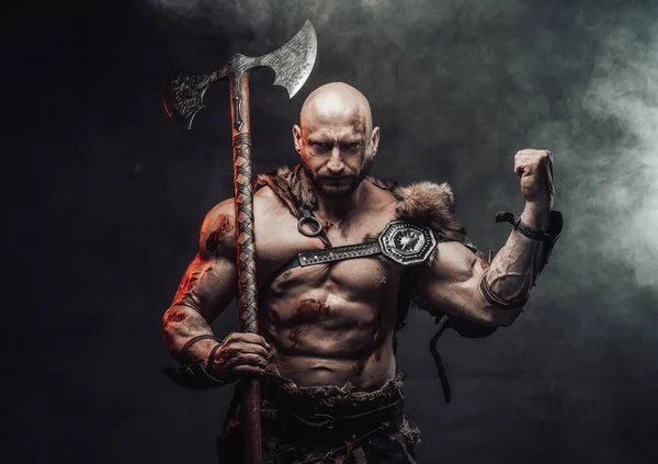 Stark vikingahållande yxa visar hans enorma biceps i rökig bakgrund — Stockfoto