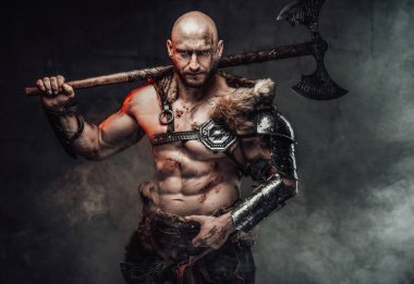 Şiddetli üstsüz Viking dumanlı arka planda omzunda kocaman bir balta taşıyor.