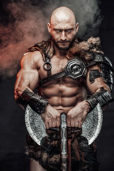 Dangerous bald scandinavian warrior with huge axe in smokey background — Stock Photo, Image