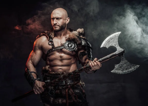 Handsome viking in antique clothing with axe in smokey background — Stock Photo, Image