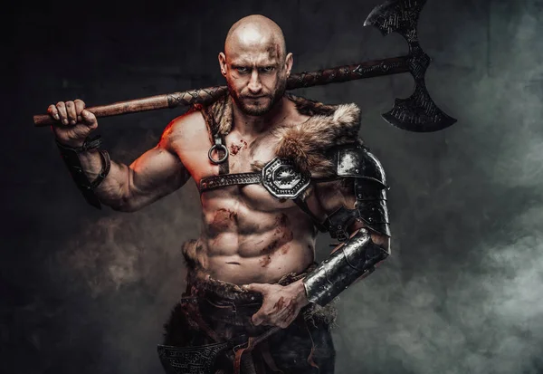 Violent topless viking holding huge axe on his shoulder in smokey background — Stock Photo, Image