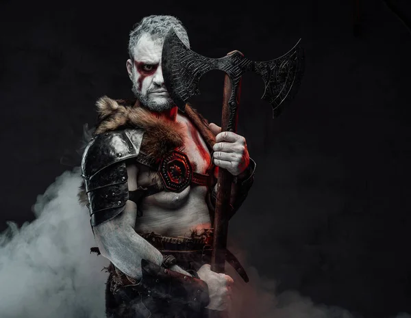 Soldado mítico bárbaro com pele pintada e machado em estúdio — Fotografia de Stock