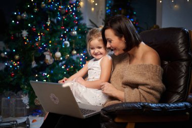 Mutlu anne ve kızı oturma odasında koltukta oturuyorlar.