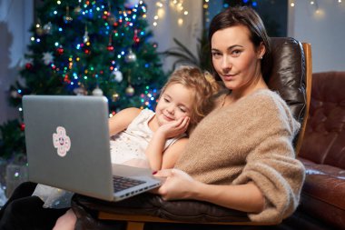 Koltukta dizüstü bilgisayarı olan mutlu anne ve kız.