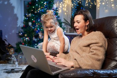 Güzel bir oturma odası, Xmas ağacı ve kızıyla birlikte bir kadın.