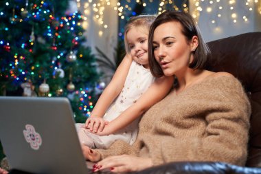 Güzel bir oturma odası, Xmas ağacı ve kızıyla birlikte bir kadın.