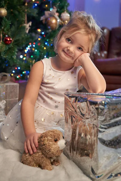 Glückliches Mädchen mit Weihnachtsgeschenk feiert Neujahr im Zimmer — Stockfoto