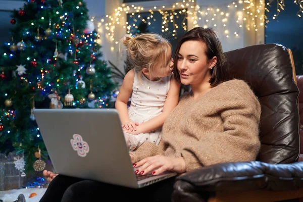 Koltukta dizüstü bilgisayarı olan mutlu anne ve kız.