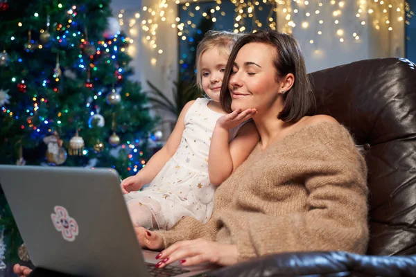 Празднование Нового года мать и дочь с ноутбуком в номере — стоковое фото