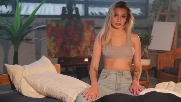 Belles poses blondes posant sur le lit dans un appartement paisible avec des œuvres d'art — Video