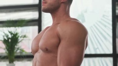 Geniş bir odada lastik geren kaslı ve sportif adam.