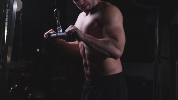 Schöner Sportler mit nacktem Oberkörper beim Training mit Trainingsgeräten im Fitnessstudio — Stockvideo