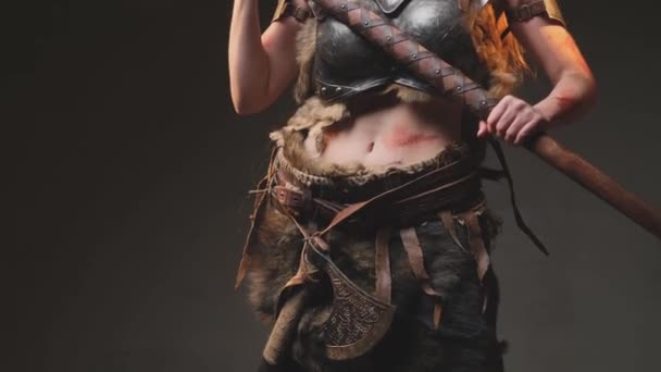 Cuerpo de violenta guerrera norteña sosteniendo un hacha en un fondo oscuro — Vídeos de Stock