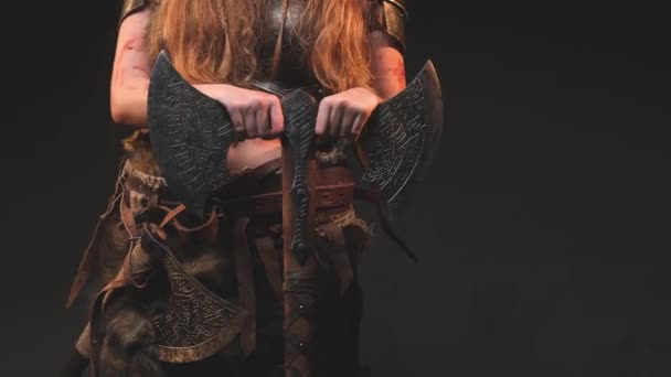 Kroppen av våldsamma norra kvinnliga krigare som håller en yxa i mörk bakgrund — Stockvideo