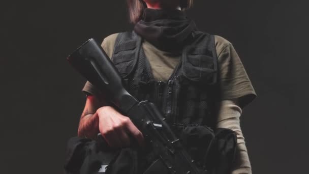 Tattooed female soldier with rifle in dark background — Stock Video