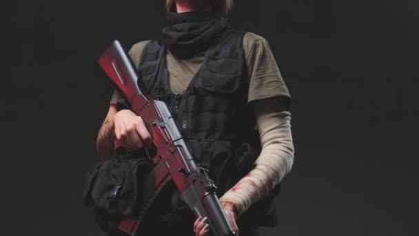 Bojová žena s ovázanou paží držící pušku ve studiu — Stock video