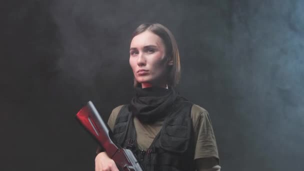 スモーキーな背景でポーズライフルを持つスタイリッシュな軍の女性 — ストック動画