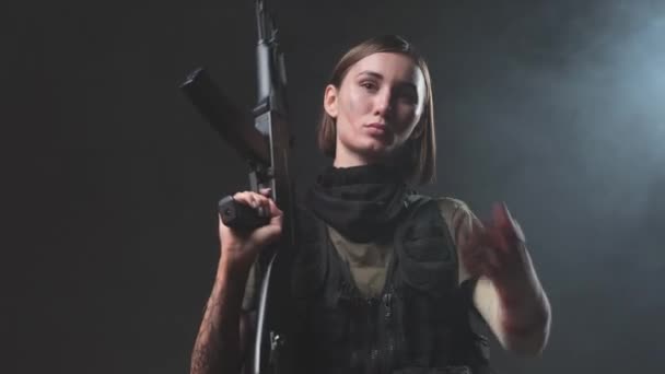 軍の女性はライフルを彼女の肩にスタジオに置く — ストック動画